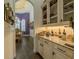 Butlers pantry with glass cabinet doors, granite countertops, and wine storage at 304 Hawk Talon Dr, Lithia, FL 33547