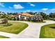 Stunning Mediterranean-style home with a circular driveway, lush landscaping, and a terracotta roof at 304 Hawk Talon Dr, Lithia, FL 33547