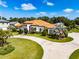 Stunning Mediterranean-style home with a circular driveway, lush landscaping, and a terracotta roof at 304 Hawk Talon Dr, Lithia, FL 33547