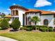 Mediterranean style home showcasing architectural details, arched windows, a terracotta roof, and manicured landscaping at 304 Hawk Talon Dr, Lithia, FL 33547