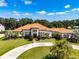 Stunning Mediterranean-style home with a circular driveway, lush landscaping, and a terracotta roof at 304 Hawk Talon Dr, Lithia, FL 33547