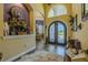 Elegant foyer with arched doorway, decorative iron double doors, and wood-look tile flooring at 304 Hawk Talon Dr, Lithia, FL 33547