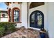 Close-up of home's front entrance with ornate double doors, arched windows, and decorative trim at 304 Hawk Talon Dr, Lithia, FL 33547