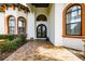 Close-up of home's front entrance with ornate double doors, arched windows, and decorative trim at 304 Hawk Talon Dr, Lithia, FL 33547