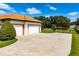 Exterior view of a home featuring a tile roof, three-car garage, and a spacious paved driveway at 304 Hawk Talon Dr, Lithia, FL 33547