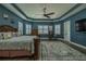An expansive main bedroom with a statement rug, wood flooring, and a ceiling fan at 304 Hawk Talon Dr, Lithia, FL 33547