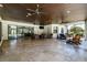 Spacious outdoor covered patio with neutral wicker furniture and travertine tile at 304 Hawk Talon Dr, Lithia, FL 33547