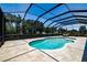 Private, screened-in pool with surrounding travertine tile, sunbathing area, and mature landscaping at 304 Hawk Talon Dr, Lithia, FL 33547