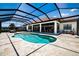 A kidney-shaped screened-in pool is surrounded by travertine tile and has a covered patio area at 304 Hawk Talon Dr, Lithia, FL 33547