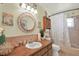 Charming bathroom featuring a wood vanity, decorative mirror, seashell decorations, and a shower-tub combination at 3060 55Th N Ave, St Petersburg, FL 33714