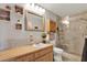 Well-lit bathroom featuring a wood vanity, decorative accents, toilet, and a glass-enclosed shower at 3060 55Th N Ave, St Petersburg, FL 33714