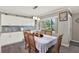 Bright dining room with a large window, modern lighting, and a gray and white backsplash behind white cabinets at 3060 55Th N Ave, St Petersburg, FL 33714