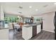 Bright kitchen featuring an island, granite countertops, stainless steel appliances, and an adjacent dining area and living room at 3060 55Th N Ave, St Petersburg, FL 33714