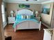 Bright bedroom with a white bed frame, hardwood floors, and coastal decor at 324 6Th Ave, Indian Rocks Beach, FL 33785
