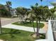 Well-manicured front yard featuring lush green grass and mature palm trees at 324 6Th Ave, Indian Rocks Beach, FL 33785