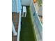 Narrow side yard featuring artificial turf and an air conditioning unit at 324 6Th Ave, Indian Rocks Beach, FL 33785