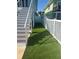 Narrow side yard featuring artificial turf and a white fence at 324 6Th Ave, Indian Rocks Beach, FL 33785