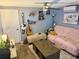 Cozy bedroom with blue walls, ceiling fan, decorative shelving, and comfortable seating area at 3970 56Th Ave N, St Petersburg, FL 33714