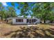 A backyard that includes a small patio area and some greenery under the shade of some trees at 4017 Moog Rd, Holiday, FL 34691