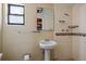 Bathroom with a sink, tiled shower, and a window for natural light at 4017 Moog Rd, Holiday, FL 34691