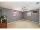 This bedroom features neutral paint, a ceiling fan, and natural light from two windows at 4017 Moog Rd, Holiday, FL 34691