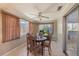 A dining area with seating for four, a ceiling fan, and natural light from the window at 4017 Moog Rd, Holiday, FL 34691