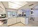 Open-concept kitchen with white cabinetry, a breakfast bar, and sliding glass doors leading to the outdoor space at 4017 Moog Rd, Holiday, FL 34691