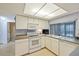 Bright kitchen featuring white cabinets and appliances, offering a functional and inviting space for culinary endeavors at 4017 Moog Rd, Holiday, FL 34691