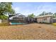 A large, fenced backyard featuring a screened-in pool and plenty of space for outdoor enjoyment at 4018 Highgate Dr, Valrico, FL 33594