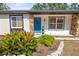 Welcoming front entrance with a bright blue door, stone accents, and manicured landscaping at 4018 Highgate Dr, Valrico, FL 33594