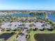 Aerial view of community clubhouse overlooking a lake with parking, tennis courts, and landscaping at 4610 Alexandria Ct, Palmetto, FL 34221