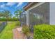 Screened-in porch with lush greenery, a tiled roof, and a well-maintained yard at 4610 Alexandria Ct, Palmetto, FL 34221