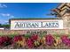 Artisan Lakes community entrance sign featuring brickwork, decorative foliage, and clear signage at 4610 Alexandria Ct, Palmetto, FL 34221