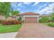 Charming single-story home featuring a tile roof, brick driveway, and manicured landscaping at 4610 Alexandria Ct, Palmetto, FL 34221