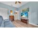 Cozy room with wood floors, blue walls, a flat screen TV and a comfortable blue sofa at 4610 Alexandria Ct, Palmetto, FL 34221