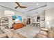Open-concept living room with tile flooring, large TV, coffered ceilings, and seamless access to the kitchen at 4610 Alexandria Ct, Palmetto, FL 34221