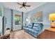 Comfortable blue living room features a plush sofa, natural light, and a ceiling fan at 4610 Alexandria Ct, Palmetto, FL 34221