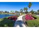 Scenic community walking path along a lake with a waterfall feature and colorful landscaping at 4610 Alexandria Ct, Palmetto, FL 34221