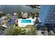 Aerial view of the community swimming pool surrounded by lush landscaping and a view of the marina at 4939 Floramar Ter # 504, New Port Richey, FL 34652