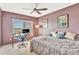 Cozy bedroom with large window providing natural light, ceiling fan, and carpeted floors at 4939 Floramar Ter # 504, New Port Richey, FL 34652