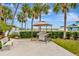 Outdoor grill station with a grill under a gazebo, a bench, and marina views at 4939 Floramar Ter # 504, New Port Richey, FL 34652