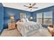 Comfortable main bedroom with blue walls, ceiling fan, and an abundance of light at 4939 Floramar Ter # 504, New Port Richey, FL 34652