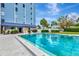 Community pool with lounge chairs and lush landscaping next to the building at 4939 Floramar Ter # 504, New Port Richey, FL 34652