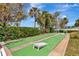 Community shuffleboard court with lush landscaping, seating, and shade trees at 4939 Floramar Ter # 504, New Port Richey, FL 34652