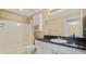 Well-maintained bathroom featuring a shower-tub combo, black granite countertop, and ample cabinet space at 501 Knights Run Ave # 1335, Tampa, FL 33602