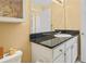Bright bathroom featuring a granite countertop, white cabinets, and ample storage with a view of the doorway at 501 Knights Run Ave # 1335, Tampa, FL 33602
