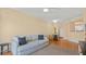 Inviting living room featuring a comfortable gray sofa, ceiling fan, and hardwood floors leading to the entrance at 501 Knights Run Ave # 1335, Tampa, FL 33602
