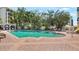 Outdoor community swimming pool surrounded by tropical foliage and brick pavers with lounge chairs nearby at 501 Knights Run Ave # 1335, Tampa, FL 33602