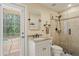 Bathroom featuring travertine shower with glass doors and granite sink at 5017 Muir Way, Lithia, FL 33547
