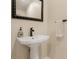 Bathroom featuring a pedestal sink with modern fixtures, decorative mirror, and towel rack at 5017 Muir Way, Lithia, FL 33547